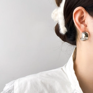 Detailed view of silver minimalist dome hoop earrings worn for a modern stylish look