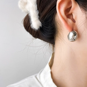 Polished silver dome stud earrings with minimalist chunky hollow design on female model