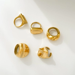Detailed view of irregular 18K gold plated titanium steel rings with textured finishes