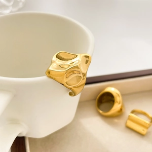 Detail view of irregular 18K gold plated molten lava rings and thick chunky band on a tray