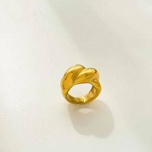 Macro detail of irregular pleated gold ring with polished finish and bold texture
