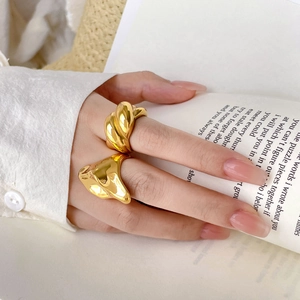 Close-up of chunky 18K gold plated irregular wavy and twisted titanium steel rings