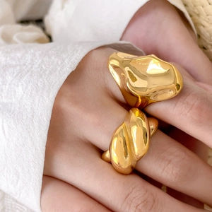 Macro detail of irregular gold ring and twisted croissant style rings on model