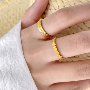 Détail de bagues dorées avec texture de feuille et design perlé pour femmes