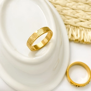 Macro shot of 18K gold plated honeycomb and sunburst engraved titanium steel rings