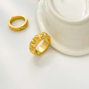 Macro detail of gold titanium steel ring with three-dimensional geometric triangle pattern