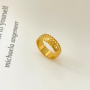 Detail of 18K gold plated ring featuring honeycomb texture on a magazine page background