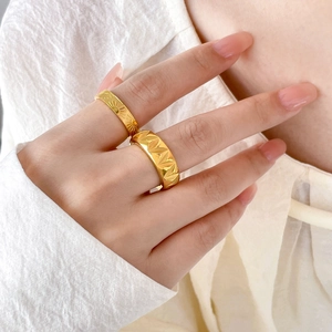Detail of 18K gold-plated rings showing radiant sunray patterns and geometric carvings