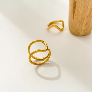 Detail of 18K gold plated titanium rings with abstract curved U-shaped wave design