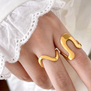 Close-up of dual gold wavy rings with 18K gold plating on model fingers with lace
