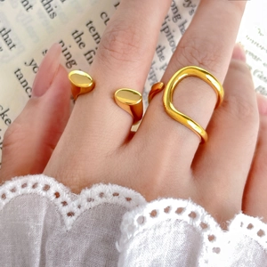 Close-up of dual-layered 18K gold-plated rings with wavy and abstract geometric design