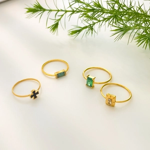 Set of four 18K gold plated rings with green zircon and black cross design