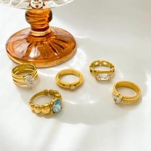 Set of five gold titanium rings with blue heart zircon and teardrop crystal accents