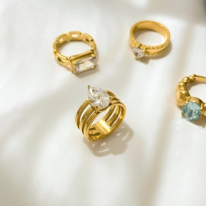 Detail of assorted gold plated titanium rings with crystal and blue zircon stones