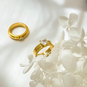 Macro detail of gold-plated heart-shaped zircon ring with textured twisted band design