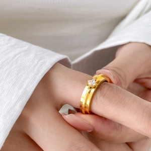 Close-up of a wide gold titanium ring featuring a square-cut clear zircon stone inlay