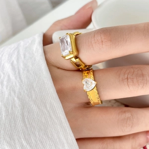 Gold plated chain ring with rectangular zircon and heart stone on a model's hand