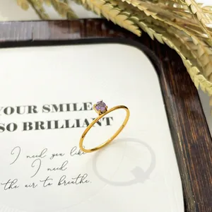 Close-up of a slim 18K gold-plated ring featuring a single round purple zircon stone