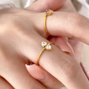 Macro shot of gold-plated rings featuring heart-shaped zircon and purple crystal stones