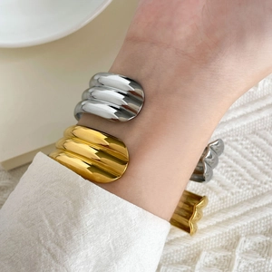 Close-up of two-tone braided titanium steel cuff bracelets with vertical striped texture