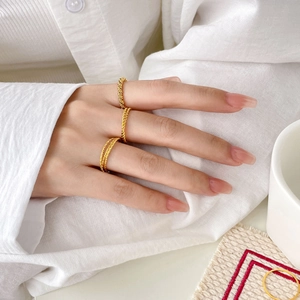 Three-piece stackable 18K gold plated titanium steel twisted rings on model hand