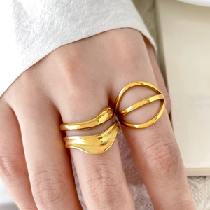 Close-up of three 18K gold plated geometric wavy and hollowed rings on fingers