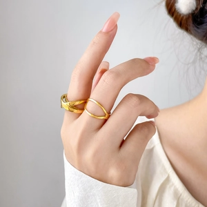 Close-up of geometric 18K gold plated hollow crisscross and double line rings on finger