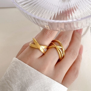 Detailed view of 18K gold plated titanium rings with geometric crossover and layered wire design