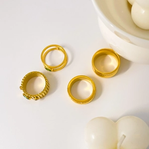 Close-up of a 4-piece 18K gold plated ring set with green zircon and gear eye details