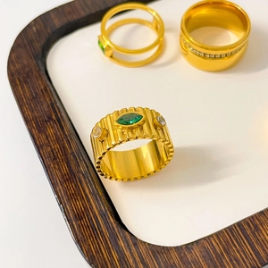 Detail of wide ribbed gold ring with marquise green zircon and side crystals