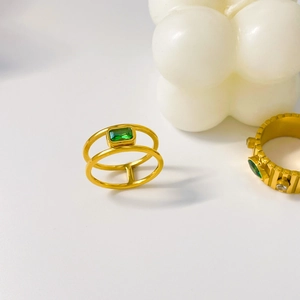 Macro detail of a 18K gold-plated double-layer ring featuring a green zircon gemstone