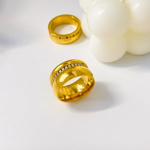 Detailed view of two wide 18K gold-plated titanium steel rings with cubic zirconia inlay