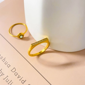 Dettaglio di anelli minimalisti placcati oro con pavé di zirconi e pietra di luna