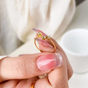 Anello sottile in acciaio al titanio dorato con tre zirconi scintillanti dal design minimal