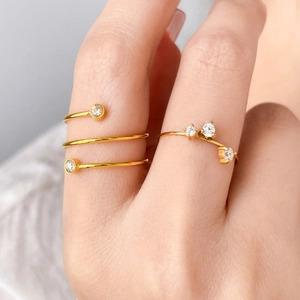 Dettaglio macro di anello a spirale dorato e fascia sottile con zirconi scintillanti