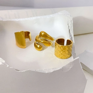 Three-piece gold minimalist ring set with flat wide band and wavy spiral textures