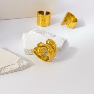Detailed view of three 18K gold plated rings with smooth and textured spiral designs