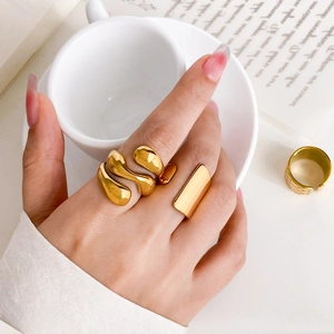 Macro detail of three 18K gold plated stackable rings with irregular liquid textures