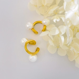 Détail de bagues d'oreille en perles plaqué or 18 carats avec pierres sur fleurs