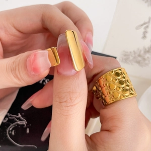Detail of 18K gold plated wide ring with hammered texture and flat bar design