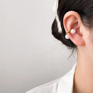 Gros plan d'un ear cuff double perle en acier plaqué or 18 carats sur l'oreille