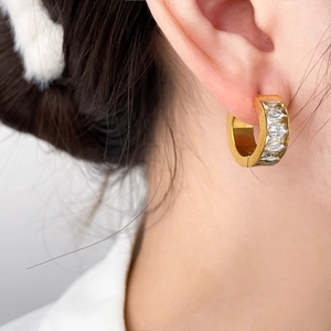 Créoles plaquées or 18 carats avec zircons rectangulaires sur un modèle féminin