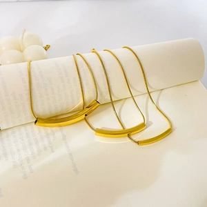 Close-up of gold-plated snake chains with minimalist rectangular bar pendants