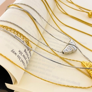 Detail of 18K gold plated croissant pendant necklaces on open book pages