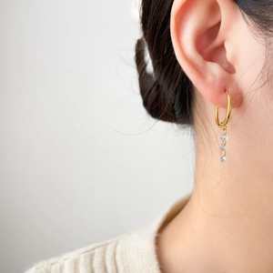 18K gold-plated titanium earrings with tassel zircon hoops worn by a model