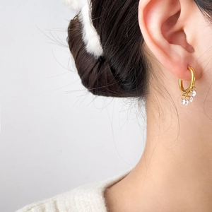 Detail of 18K gold-plated titanium tassel earrings with sparkling zircon drop accents