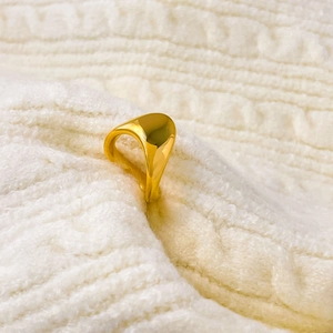 Vue détaillée d'une bague tête de souris en or sur un fond en maille blanche