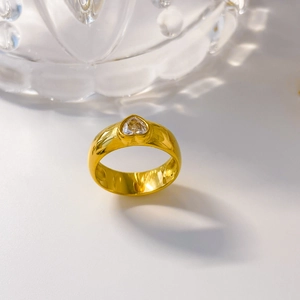 Vue macro d'une bague plaquée or avec zircon en forme de cœur sur fond de cristal