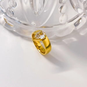 Détail d'une bague plaquée or 18K avec zircon poire sur un anneau large poli