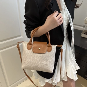 Chic woven contrasting shoulder bag with brown leather accents and gold buckle detail